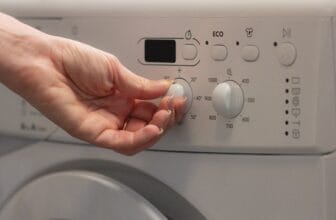女性轉動洗衣機溫度旋鈕 / Woman switching the temperature on a washing machine